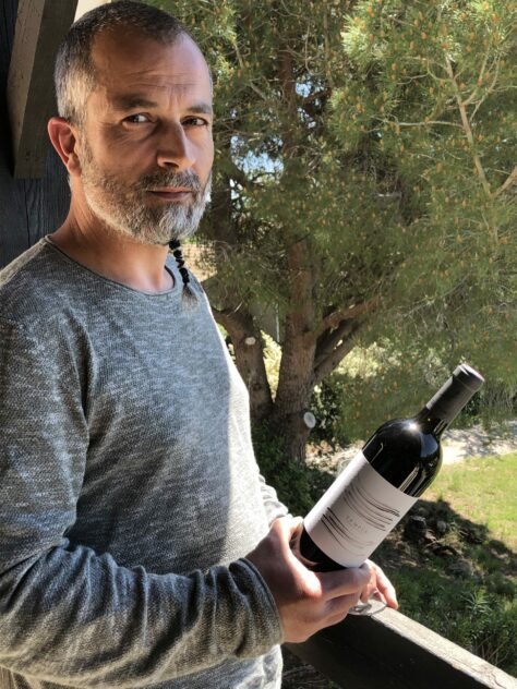 Sébastien MARTIN œnologue passionné par le vin présente une bouteille de Tempus AOP Clape rouge, grand vin du Languedoc du Château de Figuières